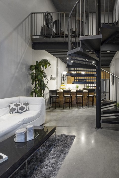 a living room with a white couch and a staircase